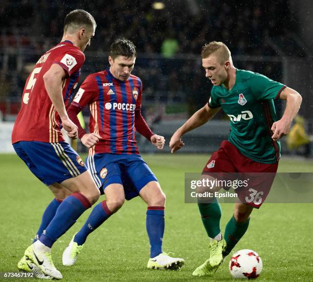 Viktor Vasin and Kirill Nababkin of PFC CSKA Moscow challenged by Dmitri Barinov of FC Lokomotiv Moscow during the Russian Premier League match...
