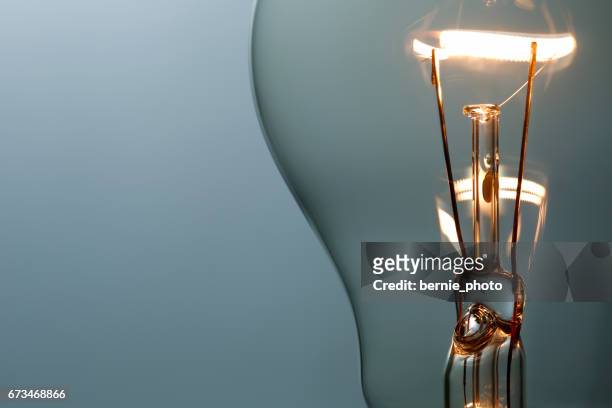 nahaufnahme leuchtende glühbirne - lightbulb stock-fotos und bilder