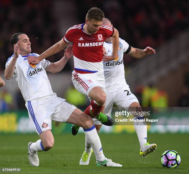 John O'Shea of Sunderland and Lee Cattermole of Sunderland tackle Ben Gibson of Middlesbrough during the Premier League match between Middlesbrough...