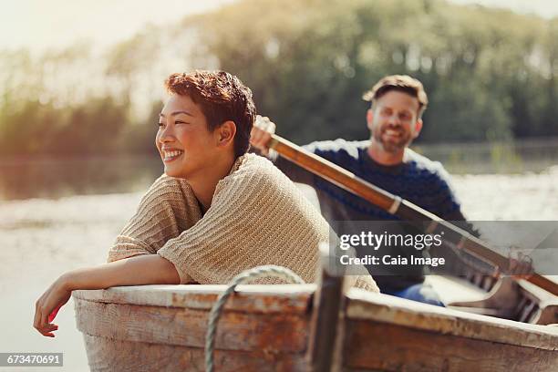 smiling couple canoeing on sunny lake - 40s couple sunny stockfoto's en -beelden