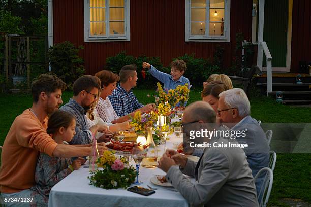 family enjoying candlelight garden dinner party - 18 23 monate stock-fotos und bilder
