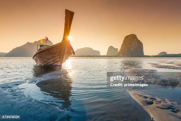 beautiful sunset at tropical sea with long tail boat in south thailand - longtail boat stock pictures, royalty-free photos & images