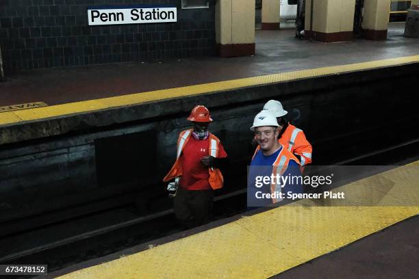 Track maintenance workers walk along train tracks used by both New Jersey Transit and Amtrak trains at Pennsylvania Station on April 26, 2017 in New...