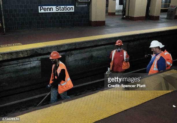 Track maintenance workers walk along train tracks used by both New Jersey Transit and Amtrak trains at Pennsylvania Station on April 26, 2017 in New...