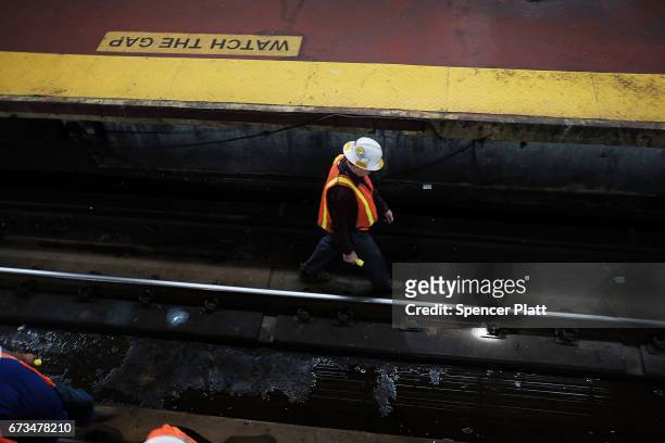 Track maintenance worker walks along train tracks used by both New Jersey Transit and Amtrak trains at Pennsylvania Station on April 26, 2017 in New...