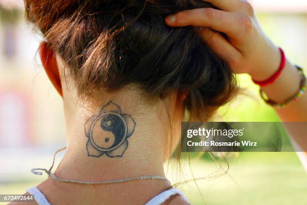 tattoo on young woman's nape - tatoeage stockfoto's en -beelden