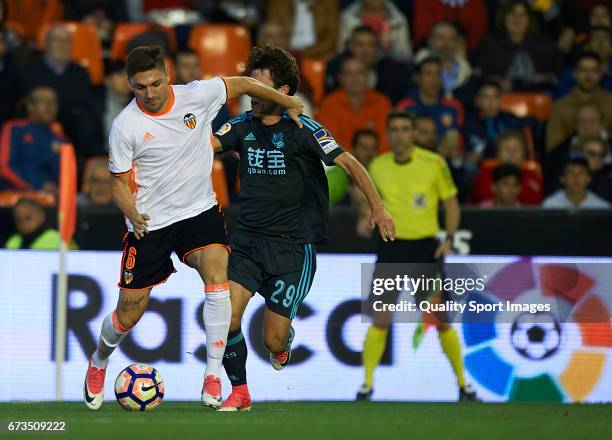 Guillherme Siqueira of Valencia competes for the ball with Alvaro Odriozola of Real Sociedad during the La Liga match between Valencia CF and Real...