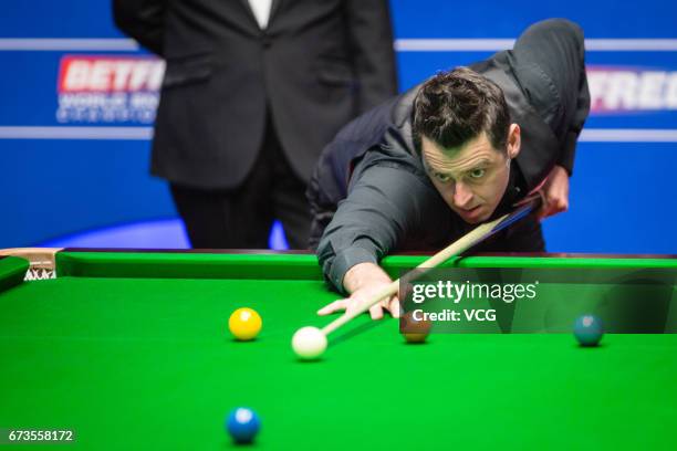 Ronnie O'Sullivan of England plays a shot during his quarter final match against Ding Junhui of China on day twelve of Betfred World Championship...