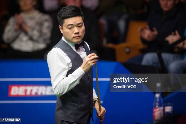 Ding Junhui of China chalks the cue during his quarter final match against Ronnie O'Sullivan of England on day twelve of Betfred World Championship...