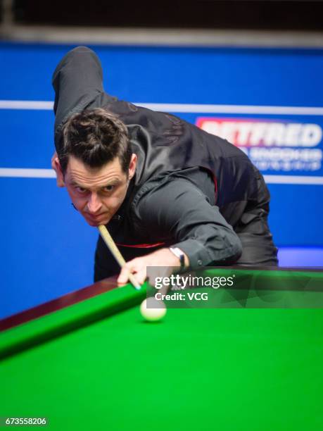 Ronnie O'Sullivan of England plays a shot during his quarter final match against Ding Junhui of China on day twelve of Betfred World Championship...