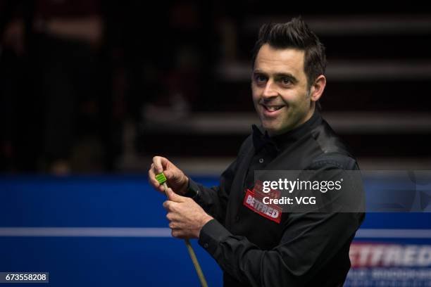 Ronnie O'Sullivan of England chalks the cue during his quarter final match against Ding Junhui of China on day twelve of Betfred World Championship...