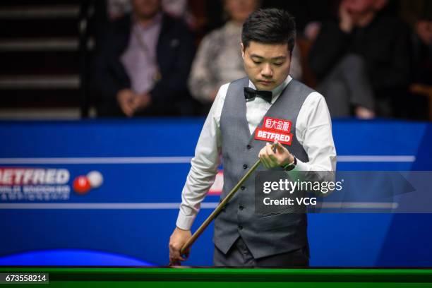 Ding Junhui of China chalks the cue during his quarter final match against Ronnie O'Sullivan of England on day twelve of Betfred World Championship...