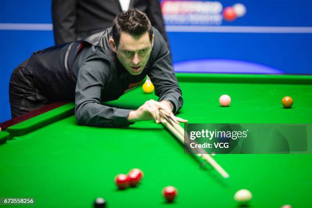 Ronnie O'Sullivan of England plays a shot during his quarter final match against Ding Junhui of China on day twelve of Betfred World Championship...