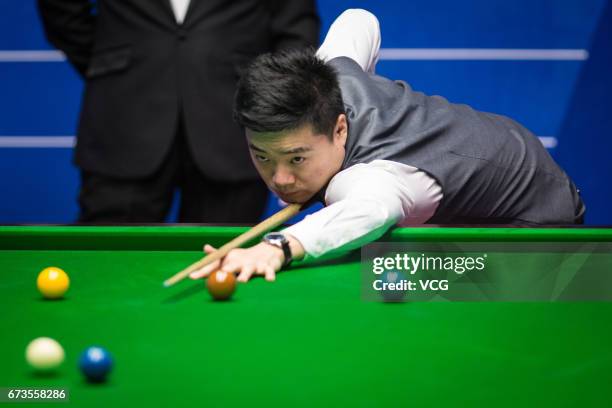 Ding Junhui of China plays a shot during his quarter final match against Ronnie O'Sullivan of England on day twelve of Betfred World Championship...