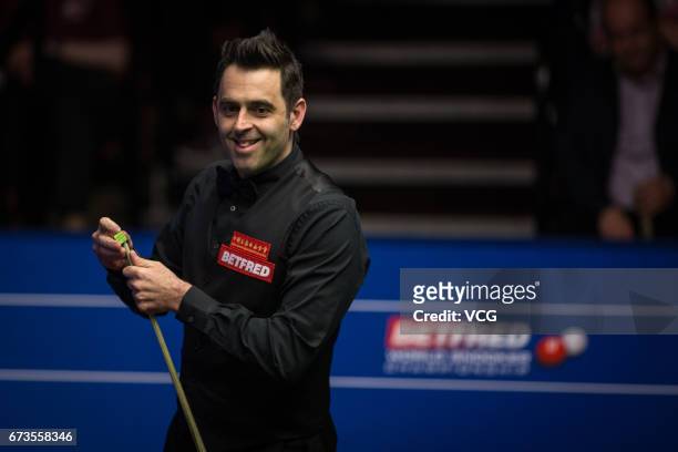 Ronnie O'Sullivan of England chalks the cue during his quarter final match against Ding Junhui of China on day twelve of Betfred World Championship...