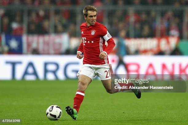 Philipp Lahm of Muenchen runs with the ball during the DFB Cup semi final match between FC Bayern Muenchen and Borussia Dortmund at Allianz Arena on...