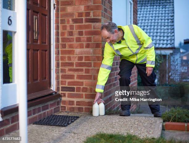 milkman leaving milk by customer's door - milk man fotografías e imágenes de stock
