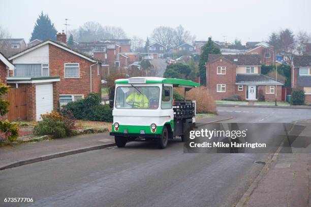 milkman driving his milk float up an urban street - milkman - fotografias e filmes do acervo