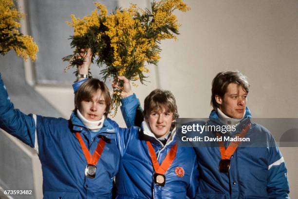 Matti Nykanen of Finland , Jens Weissflog of the German Democratic Republic , and Jari Puikkonen of Finland wave to the crowd during the medal...