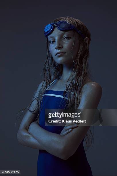 portrait of young swimmer with crossed arms - sport blue background stock-fotos und bilder