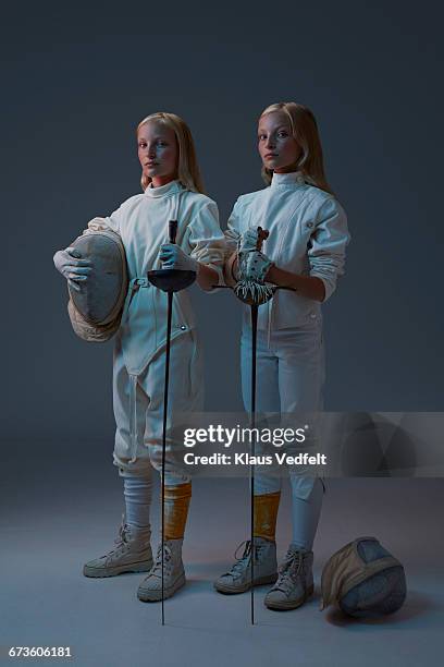 portrait of 2 young twin fencers looking to camera - twin photos et images de collection