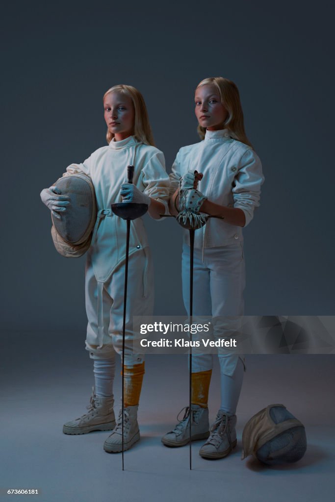 Portrait of 2 young twin fencers looking to camera