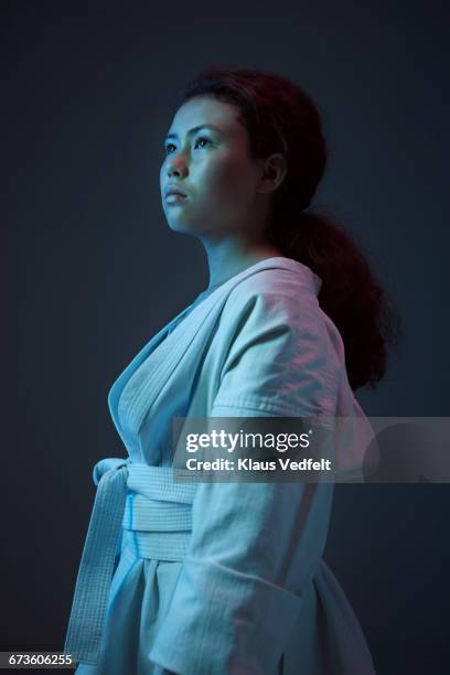 portrait of young female martial arts athlete - sport blue background stockfoto's en -beelden