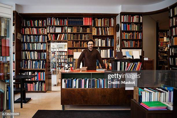 portrait of owner standing against bookshelves in library - book shop 個照片及圖片檔