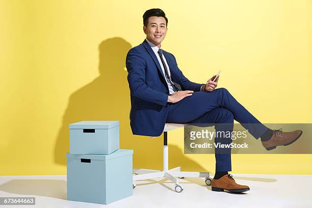 young business man - sitting and using smartphone studio stockfoto's en -beelden