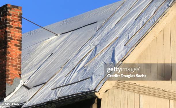 emergency covering attached to a damaged building roof - diy disaster stock pictures, royalty-free photos & images