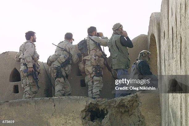 American and British special operations soldiers observe fighting between Northern Alliance troops and pro-Taliban forces November 27, 2001 in a...