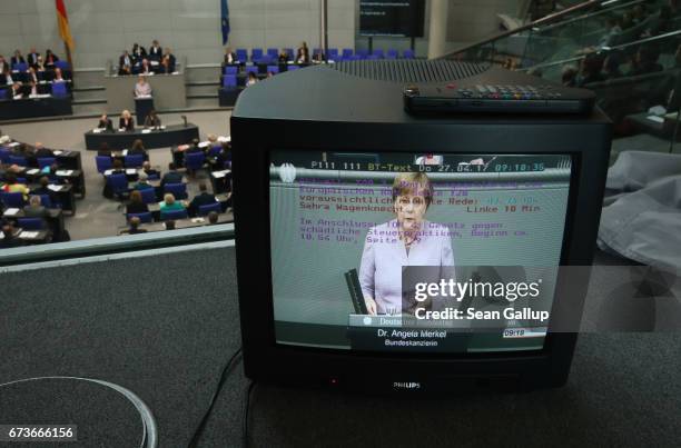 German Chancellor Angela Merkel is seen on a monitor as she gives a government declaration outlining Germany's position on negotiations over the...