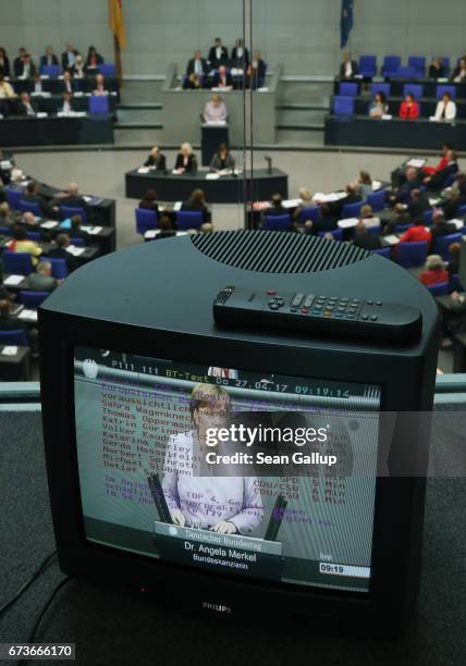 German Chancellor Angela Merkel is seen on a monitor as she gives a government declaration outlining Germany's position on negotiations over the...
