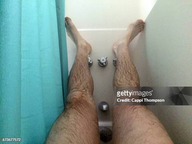 feet resting in the shower - behaart stock-fotos und bilder