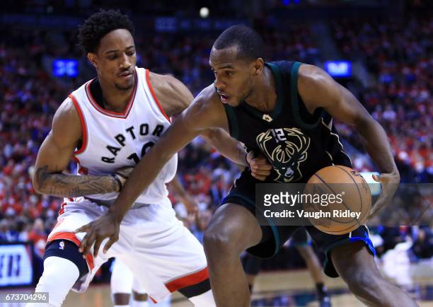Khris Middleton of the Milwaukee Bucks dribbles the ball as DeMar DeRozan of the Toronto Raptors defends in the second half of Game Five of the...