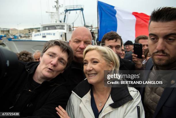 French presidential election candidate for the far-right Front National party Marine Le Pen , escorted by her bodyguard Thierry Legier , poses for a...