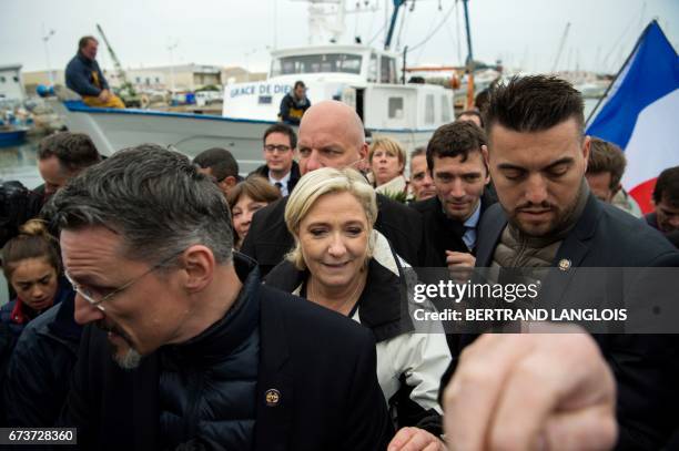 French presidential election candidate for the far-right Front National party Marine Le Pen , followed by her bodyguard Thierry Legier , walks past...