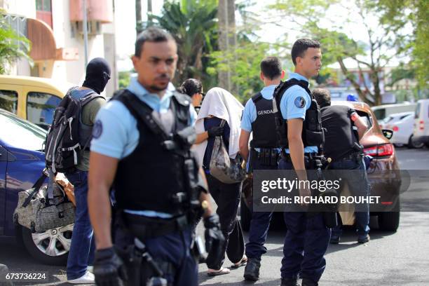 French gendarmes and police officers escort a person on April 27, 2017 in Saint-Denis-de-la-Reunion, on the French Indian Ocean island of Reunion,...