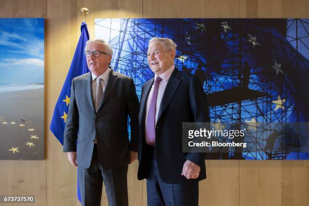 George Soros, billionaire and founder of Soros Fund Management LLC, right, and Jean-Claude Juncker, president of the European Commission, pose for a...