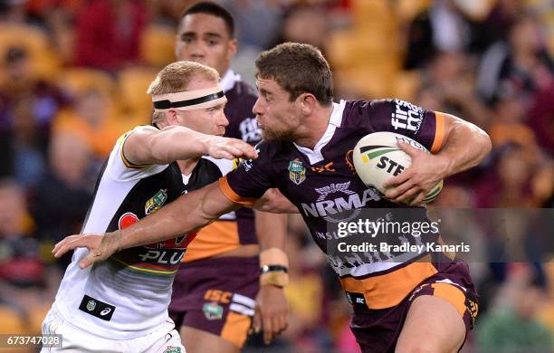 Andrew McCullough of the Broncos attempts to break away from the defence of Peter Wallace of the Panthers during the round nine NRL match between the...