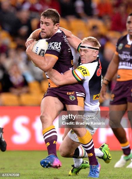 Andrew McCullough of the Broncos attempts to break away from the defence of Peter Wallace of the Panthers during the round nine NRL match between the...