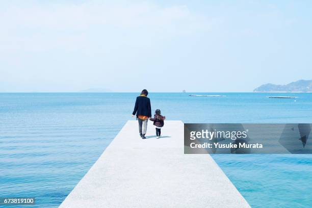 mother and child holding hands on pier - 2 people back asian imagens e fotografias de stock