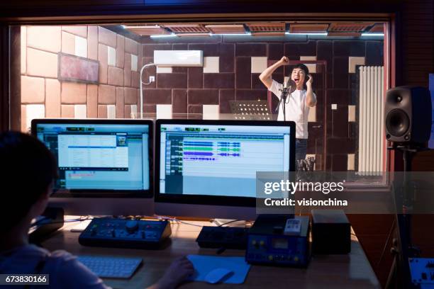 young male singer singing in studio,technician in foreground - switchboard operator stock pictures, royalty-free photos & images