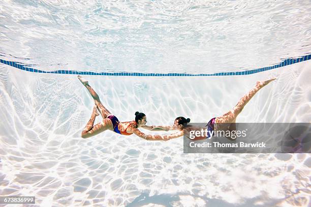 synchronized swimmers holding hands during routine - synchronized swimming photos et images de collection
