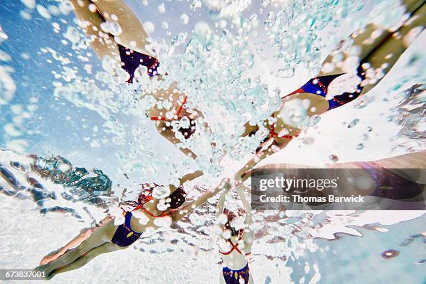 synchronized swimmers on surface holding hands - synchronized swimming stock pictures, royalty-free photos & images
