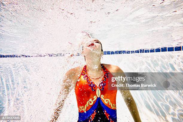 female synchronized swimmer swimming to surface - synchronized swimming photos et images de collection