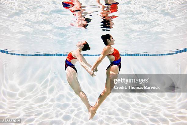 synchronized swimmers in heart shape underwater - two hearts fotografías e imágenes de stock