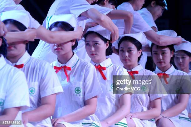 Nursing students receive nurses' caps during a ceremony ahead of the International Nurses Day on April 27, 2017 in Taiyuan, Shanxi Province of China....