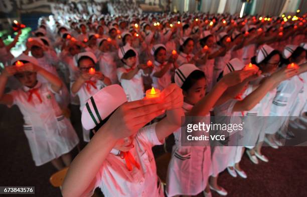 Nursing students holding candle shaped lights attend a ceremony ahead of the International Nurses Day on April 27, 2017 in Taiyuan, Shanxi Province...