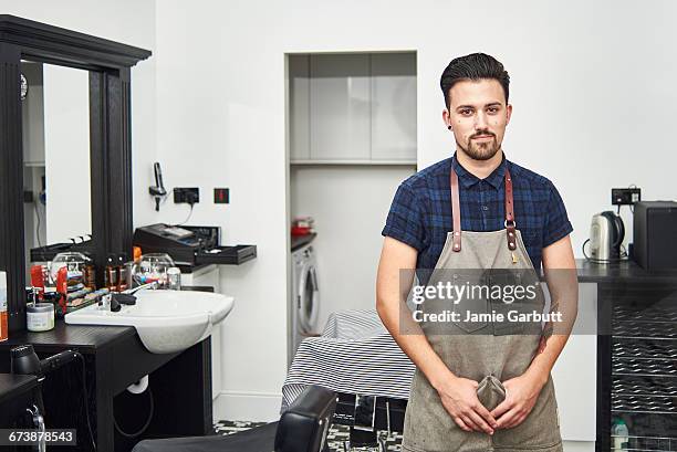 young british apprentice barber standing proudly - barbeiro imagens e fotografias de stock